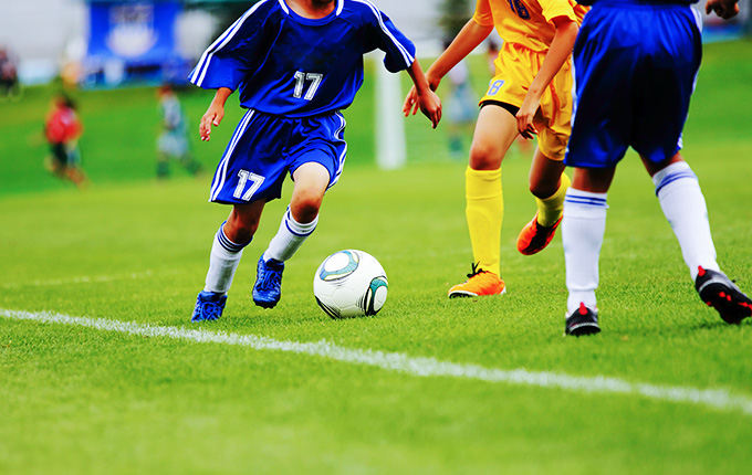 サッカーボールを取り合う子供達